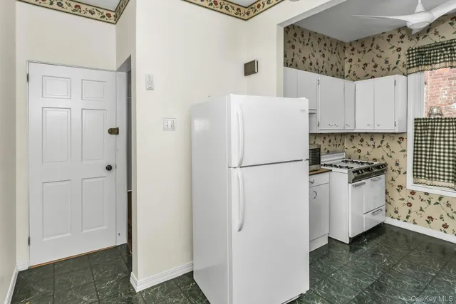 a white refrigerator freezer sitting inside of a kitchen