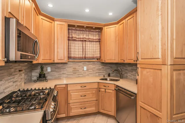 a kitchen with stainless steel appliances granite countertop a sink a stove and a refrigerator