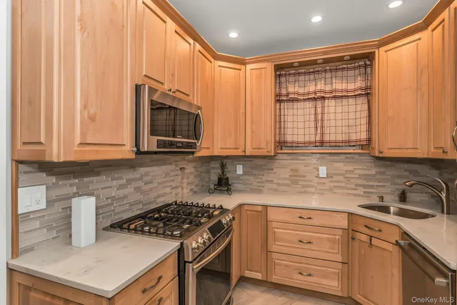 a kitchen with stainless steel appliances granite countertop a sink a stove and a microwave