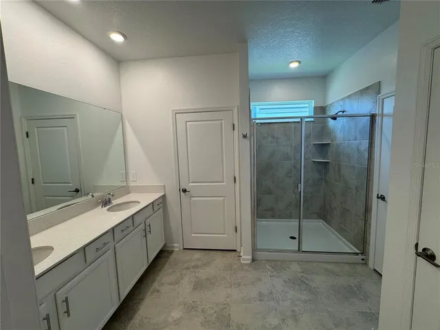 a bathroom with a double vanity sink mirror and shower