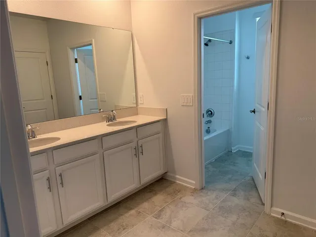 a bathroom with a double vanity sink and mirror