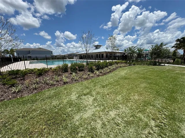 a view of a big yard with plants and large trees