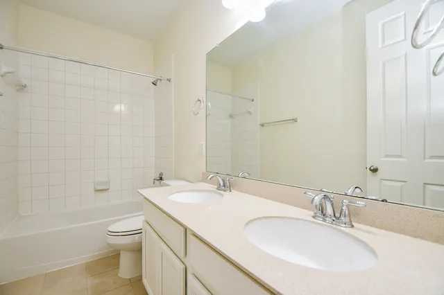 a bathroom with a granite countertop sink a toilet and shower