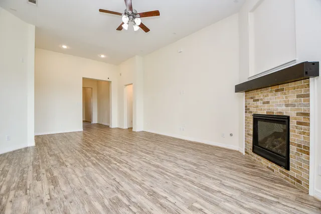 a view of empty room with wooden floor and fireplace