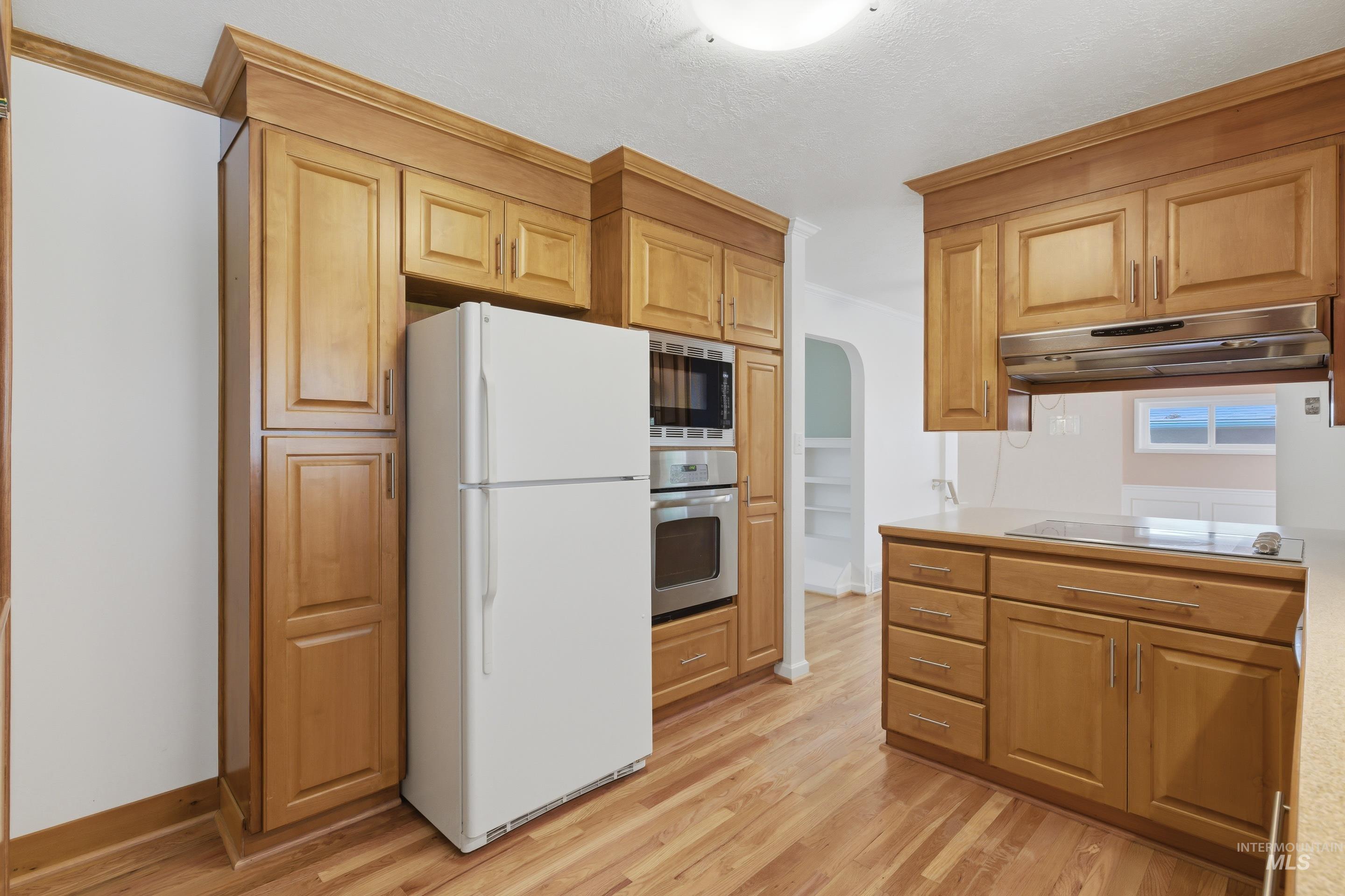 504 West Howe Street Boise, ID 83706 - Photo 18 of 47 Kitchen featuring wood cabinetry, integrated stainless steel appliances, light-toned countertops, and wood-finish flooring