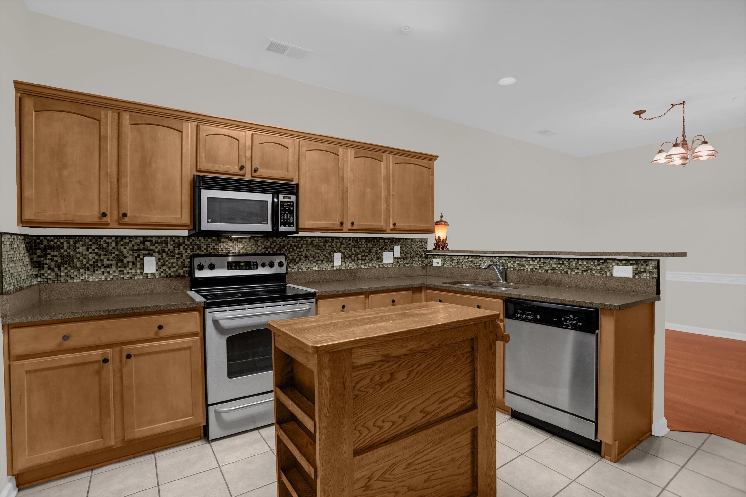 34 Peyton Ridge Drive, Unit 21 Collierville, TN 38017 - Photo 15 of 37 Kitchen featuring wood cabinetry, stainless steel appliances, a mosaic tile backsplash, and a central wood island