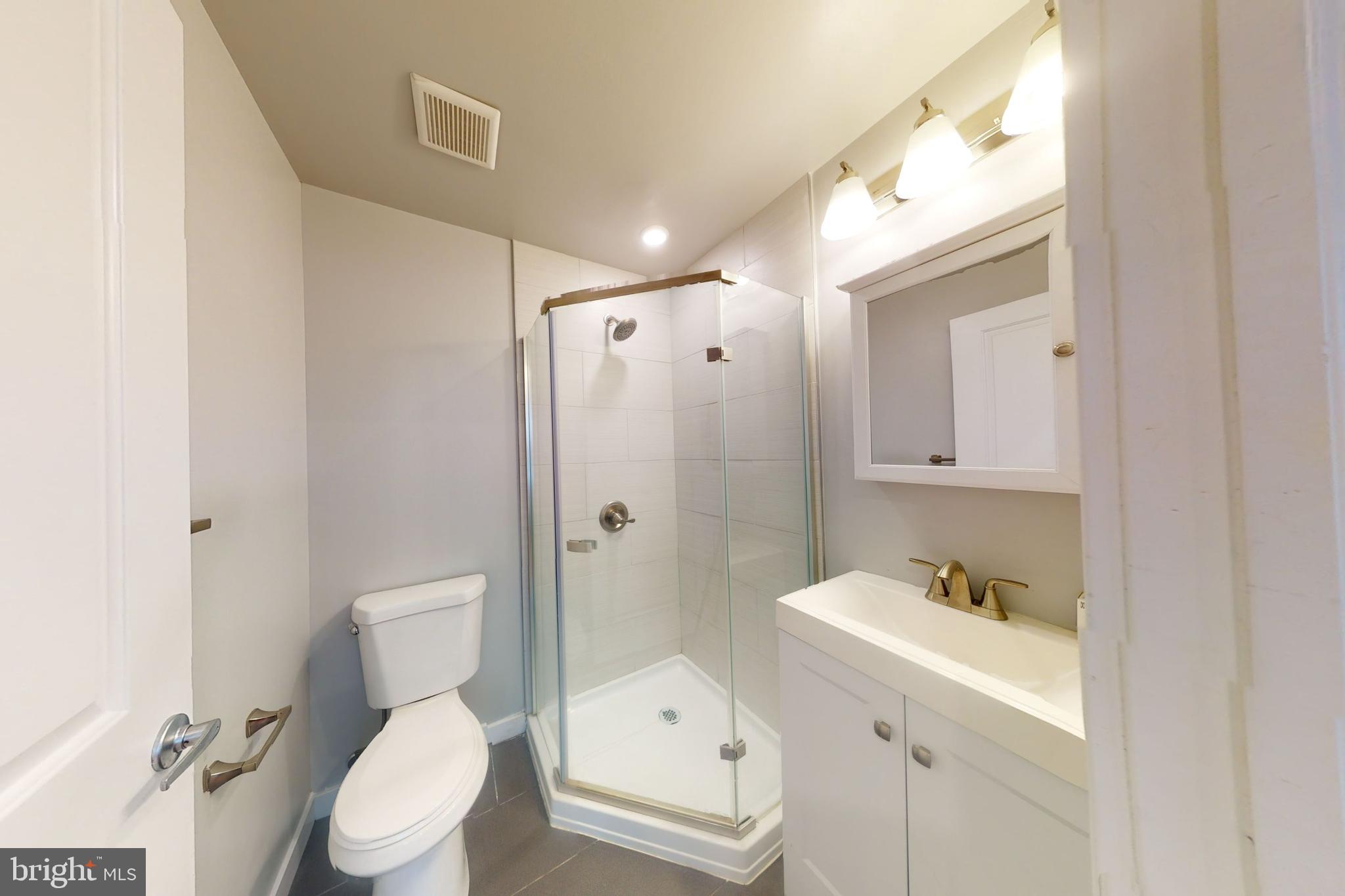 1517 West Seybert Street, Unit 1 Philadelphia, PA 19121 - Photo 3 of 5 a bathroom with a toilet sink shower and mirror