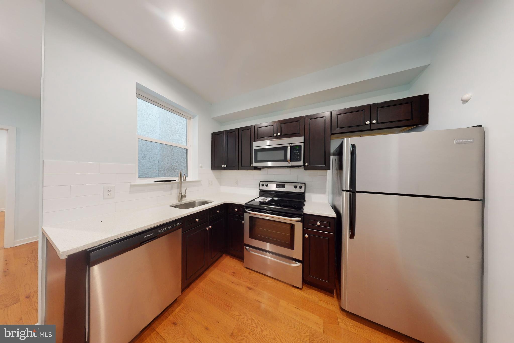 1517 West Seybert Street, Unit 1 Philadelphia, PA 19121 - Photo 5 of 5 a kitchen with stainless steel appliances a refrigerator stove microwave and sink