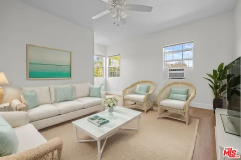 a living room with furniture a chandelier and a window