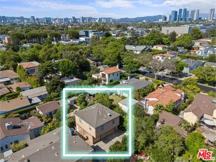 an aerial view of residential houses with outdoor space and parking