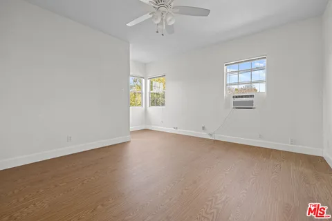 an empty room with a window and a ceiling fan