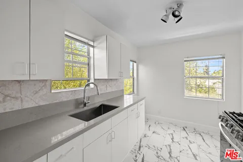 a kitchen with stainless steel appliances a sink a stove and a window