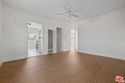 a view of a livingroom with wooden floor and a ceiling fan