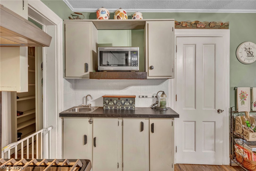 6144 Ridge Road Wadsworth, OH 44281 - Photo 18 of 48 Kitchen with backsplash, sink, light hardwood / wood-style floors, and ornamental molding