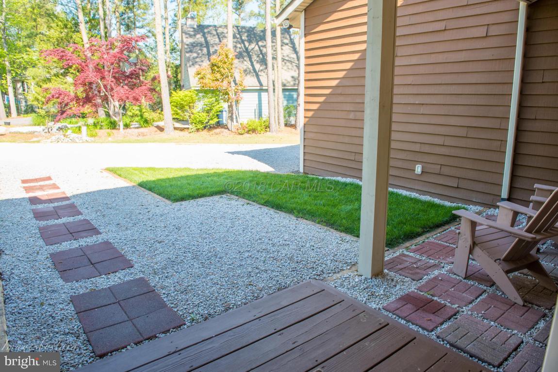 36 Saltgrass Road Ocean Pines, MD 21811 - Photo 56 of 70 a view of a backyard with plants and wooden bench