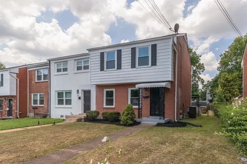 a view of a brick house with a large windows and a large tree
