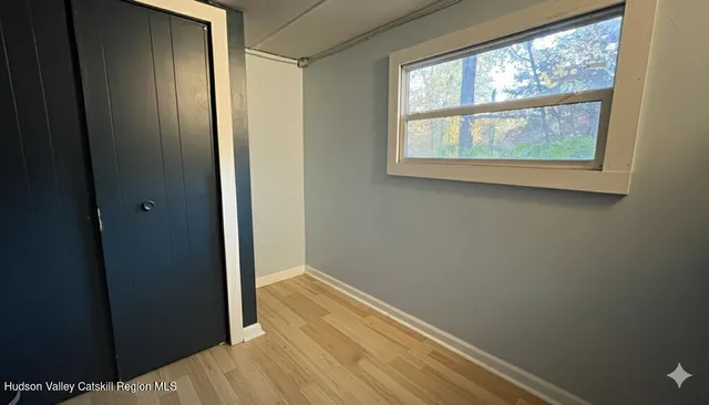 a view of a small space with wooden floor and a window
