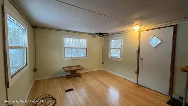 a view of a livingroom with wooden floor and a window