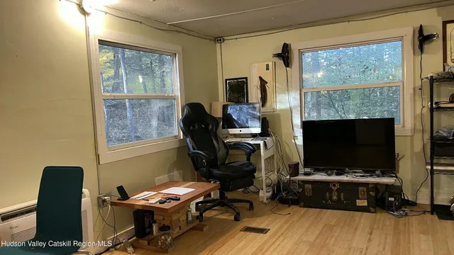 a view of a workspace with furniture and a flat screen tv