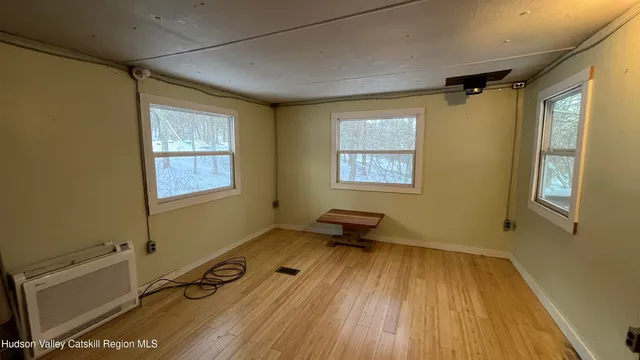 a room with gym equipment on wooden floor and a window