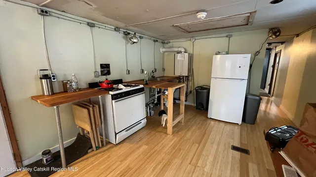 a kitchen with a refrigerator a sink and wooden floor