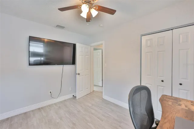 a view of a hallway with wooden floor and a living room
