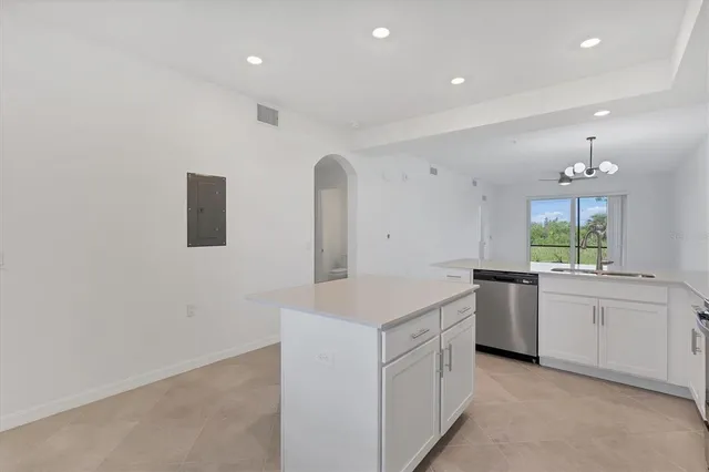 a kitchen with white cabinets and sink