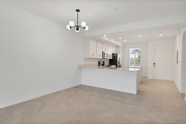 a view of a kitchen with a refrigerator and a chandelier