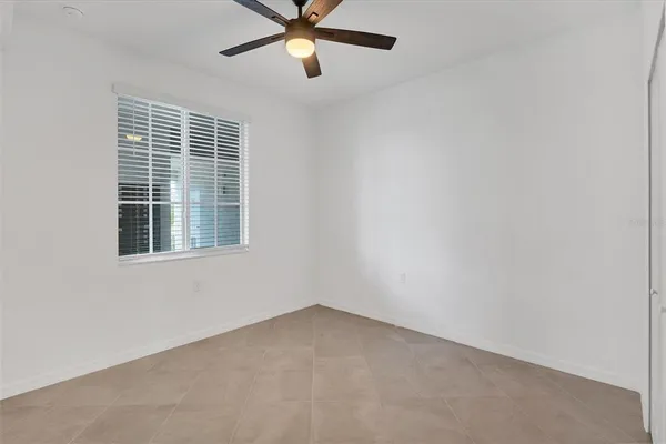 an empty room with a window and a fan
