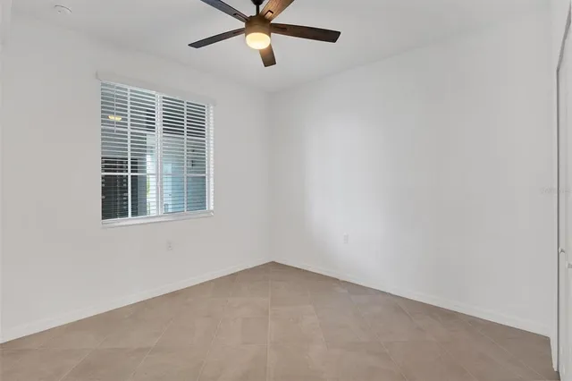 an empty room with a window and a fan