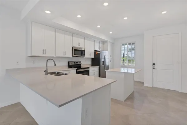 a kitchen with sink a microwave and refrigerator