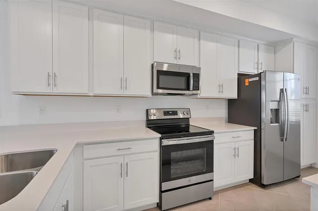a kitchen with white cabinets and stainless steel appliances