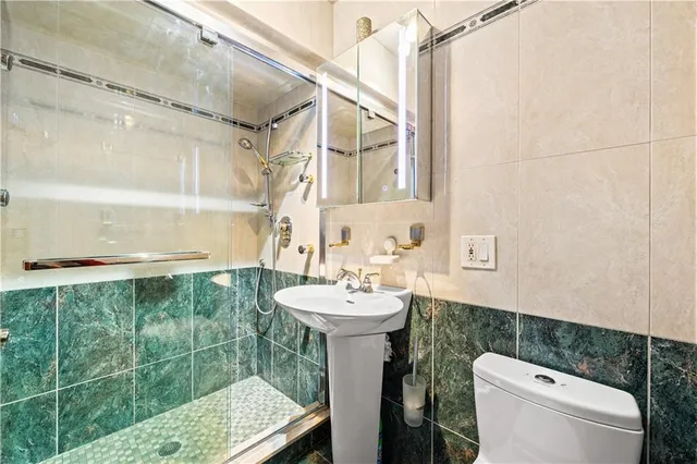 a bathroom with a sink a toilet and shower
