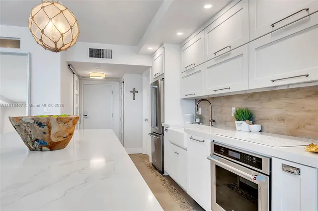 a kitchen with stainless steel appliances granite countertop a sink a stove and cabinets
