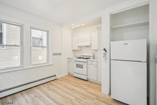 a kitchen with granite countertop white cabinets and white appliances