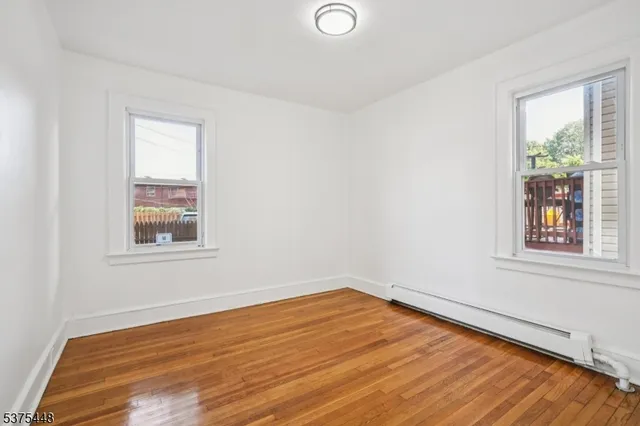 a view of a room with wooden floor and window