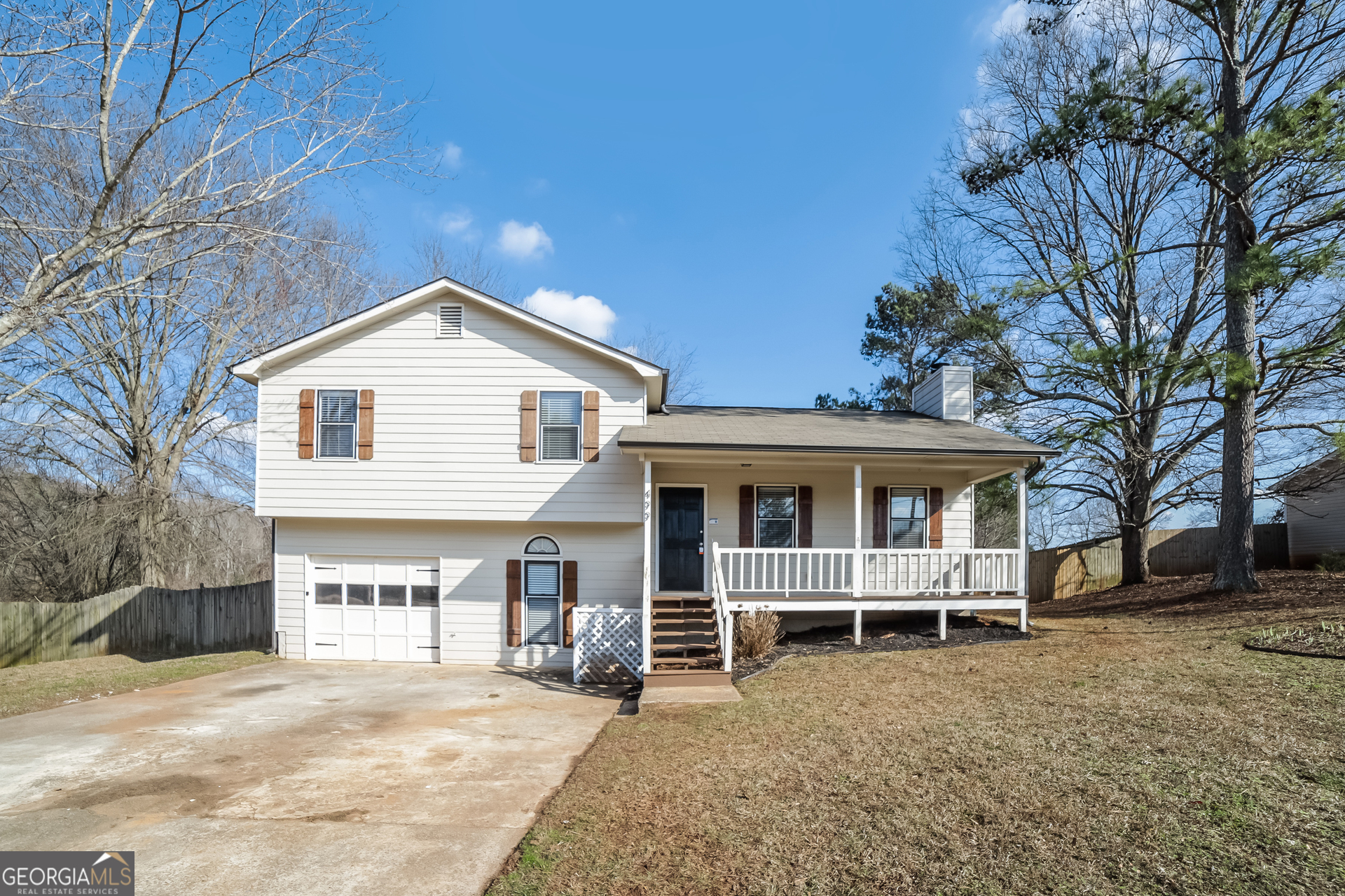a view of a house with a yard and large tree