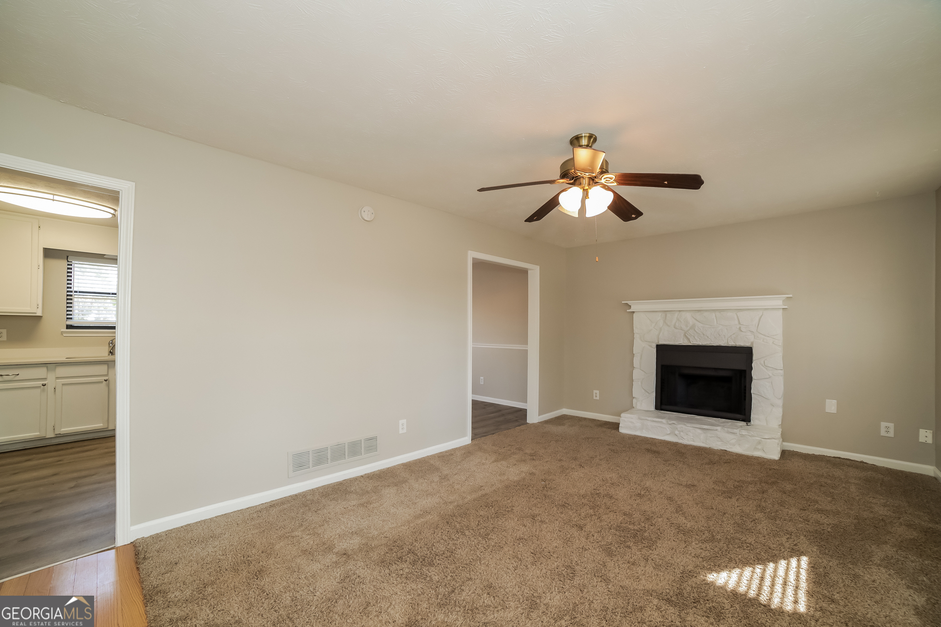 499 Woodland Street Dallas, GA 30157 - Photo 4 of 17 an empty room with chandelier fan and fireplace