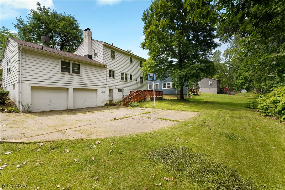 542 Garnette Road Akron, OH 44313 - Photo 3 of 24 Rear exterior featuring a two-car garage, white siding, a concrete patio area, and a wood deck