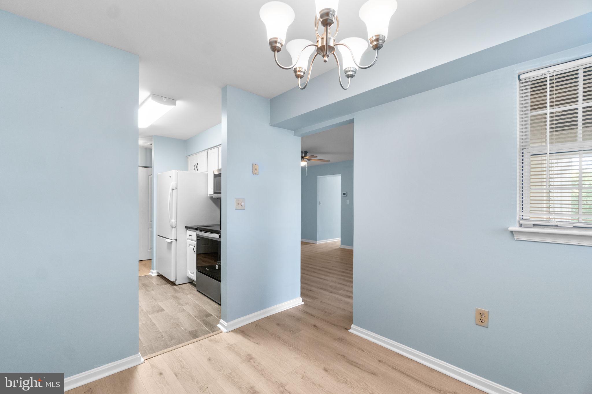 8378 Montgomery Run Road, Unit D Ellicott City, MD 21043 - Photo 12 of 30 a view of a hallway with wooden floor and a chandelier