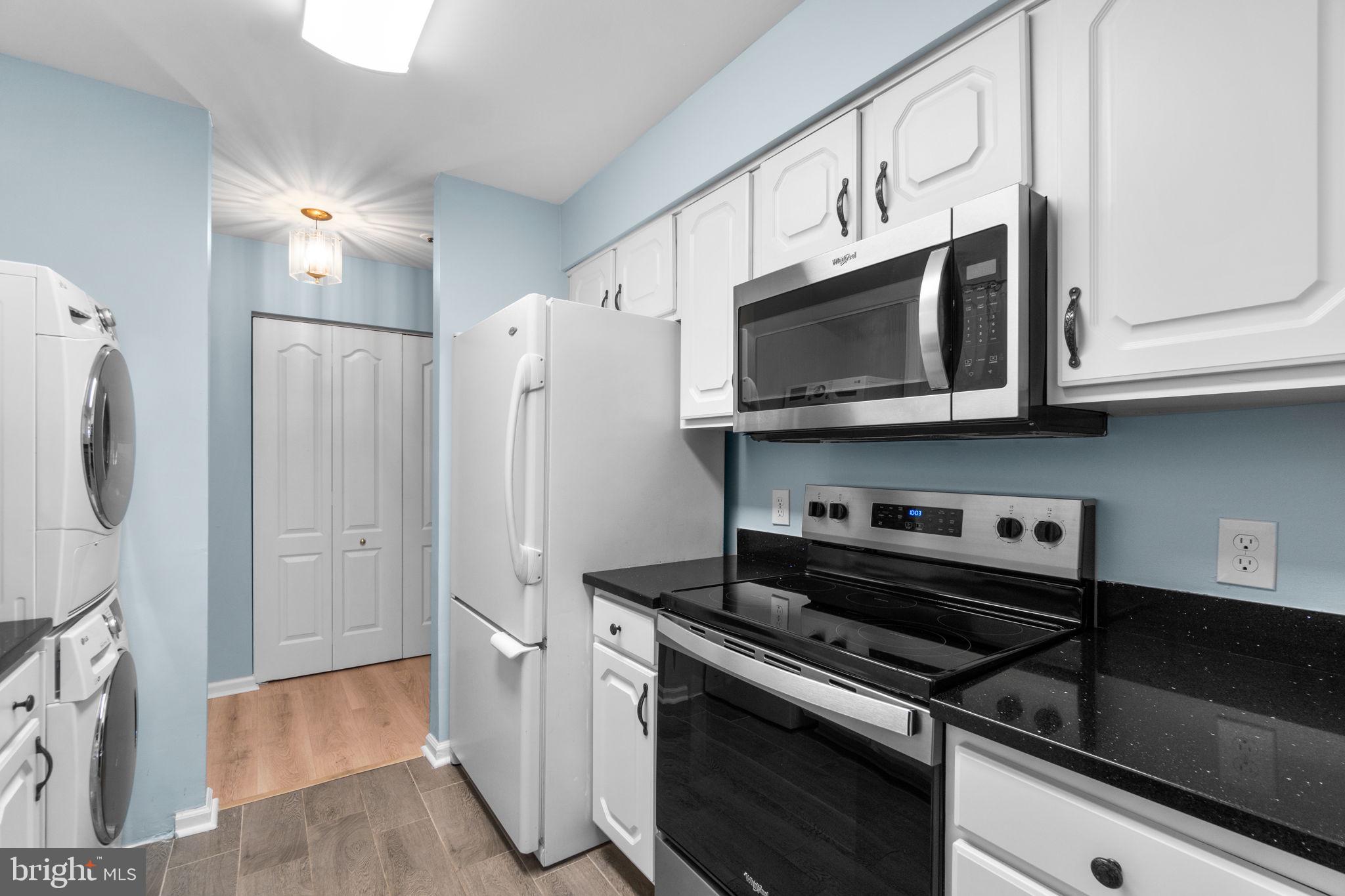8378 Montgomery Run Road, Unit D Ellicott City, MD 21043 - Photo 13 of 30 a kitchen with stainless steel appliances granite countertop a refrigerator a stove and a microwave