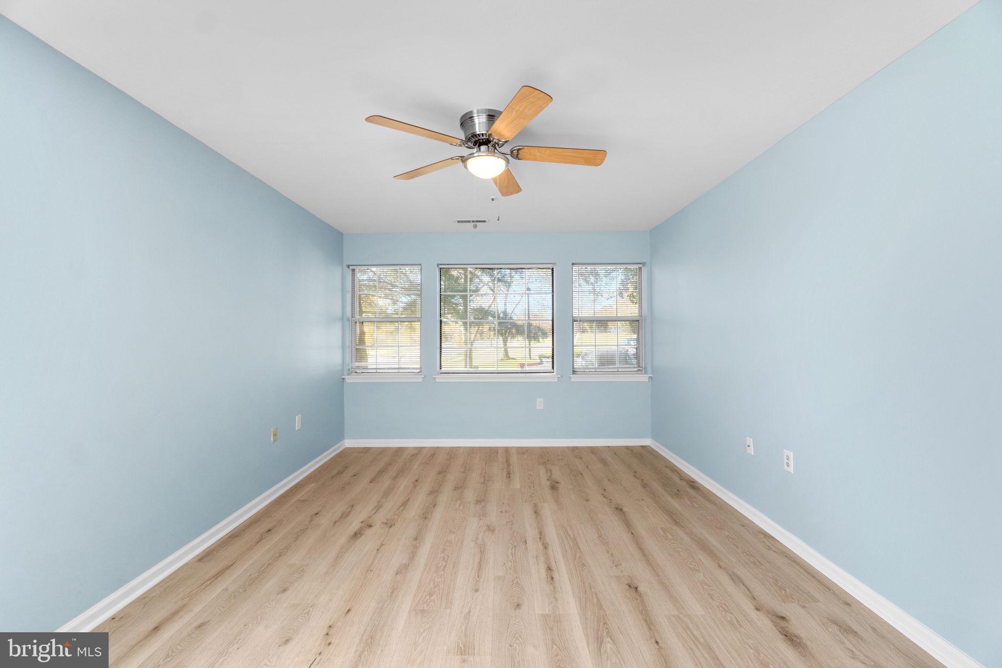 8378 Montgomery Run Road, Unit D Ellicott City, MD 21043 - Photo 23 of 30 an empty room with wooden floor fan and windows