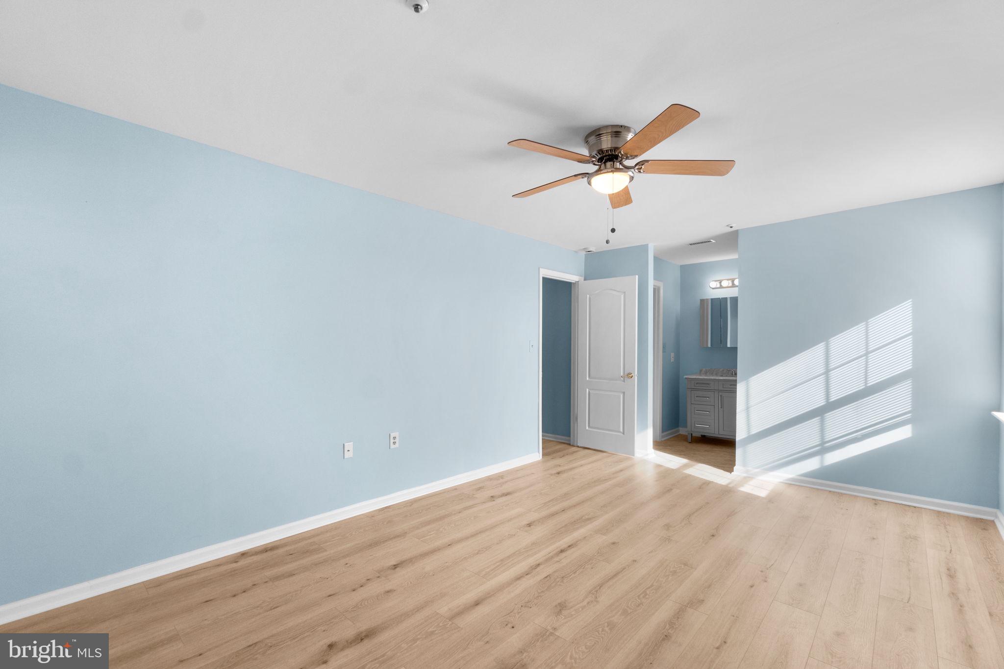 8378 Montgomery Run Road, Unit D Ellicott City, MD 21043 - Photo 25 of 30 a view of a room with wooden floor and a ceiling fan