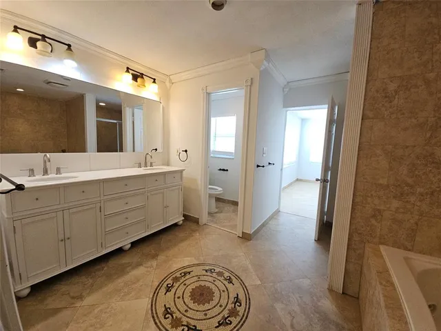 a spacious bathroom with a double vanity sink a mirror and a shower