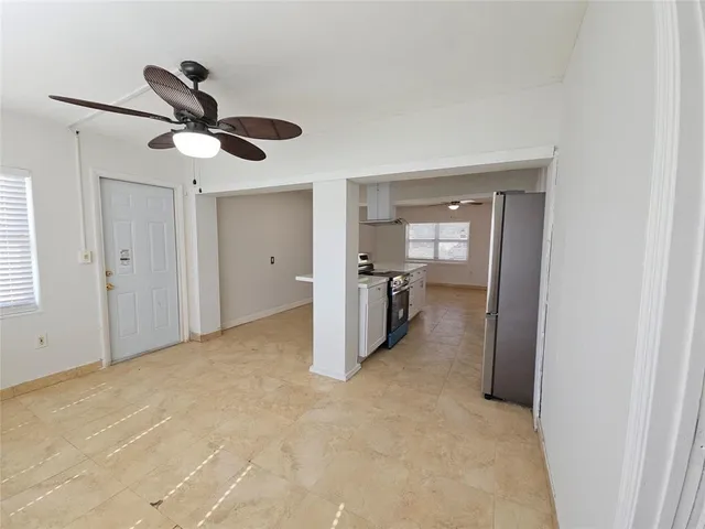 a view of a livingroom with a ceiling fan & entryway
