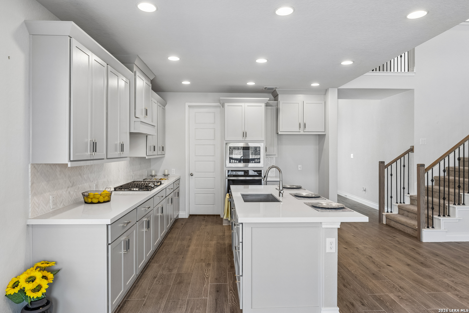 63 Ricadonna San Antonio, TX 78253 - Photo 11 of 43 a kitchen with stainless steel appliances a stove a sink a refrigerator white cabinets and wooden floor