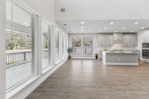 a view of kitchen with kitchen island stainless steel appliances wooden cabinets and window