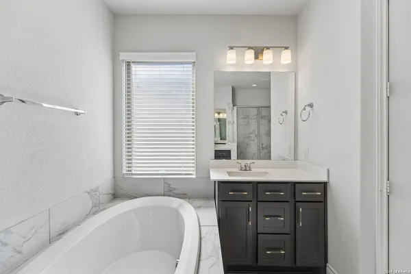 a bathroom with a granite countertop sink mirror and shower