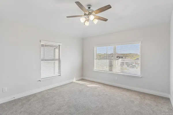 an empty room with a window and a fan