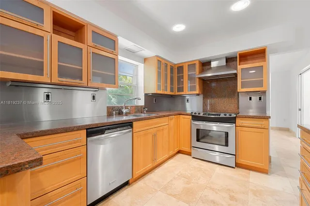 a kitchen with kitchen island granite countertop wooden cabinets a refrigerator and a sink